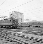 859417 Afbeelding van de electrische locomotief nr. 1138 (serie 1100) van de N.S. met rechts een rijtuig plan W in een ...